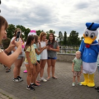 Dzieci pozujące do zdjęcia z kaczorem Donaldem