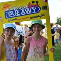 Dwoje dzieci trzymający dużą ramkę do zdjęć z napisem Puławy